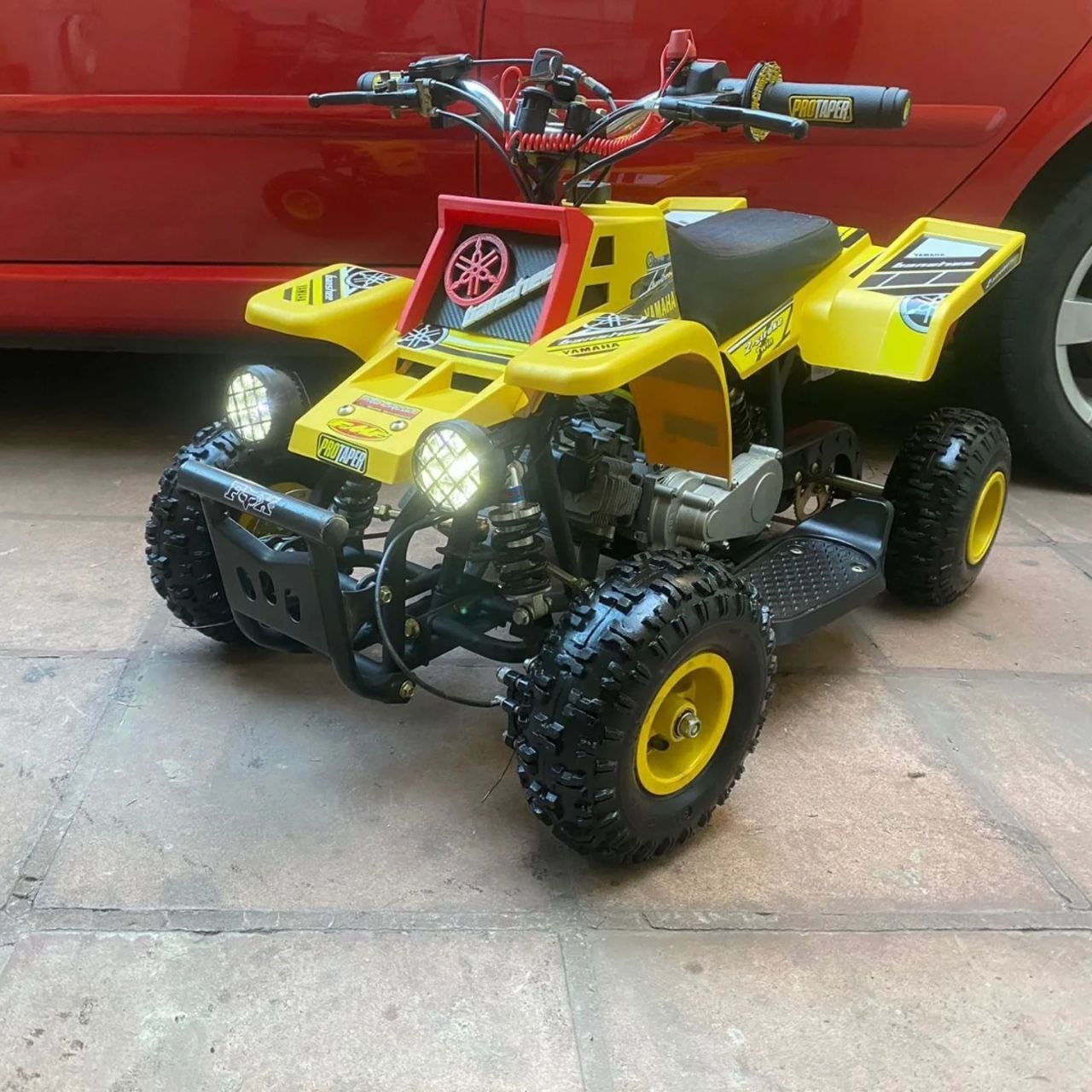 Person mixing 2-stroke fuel for a kids 49cc mini Banshee gas powered bike